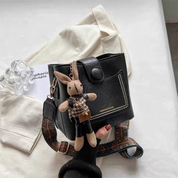 کیف وارداتی دوشی و دستی زنانه مدل باکسی چرم همراه با بند پهن ژاکارد و آویز عروسکی (مشکی 1052)